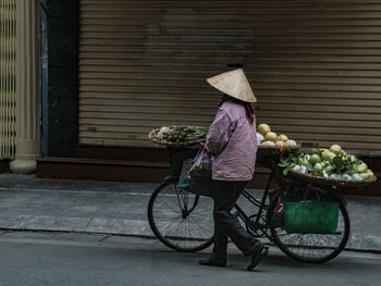 Man with bicycle on street in city