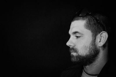 Close-up of young man against black background