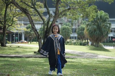 Portrait of girl in traditional clothing walking on field