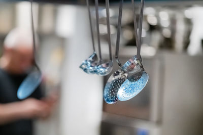 Ladles hanging from the rack in a restaurant.