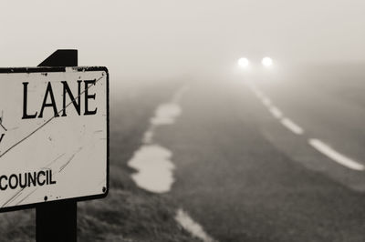 Close-up of road sign against sky