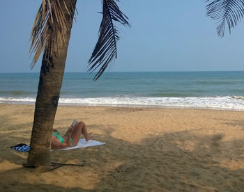 Low section of woman relaxing on beach