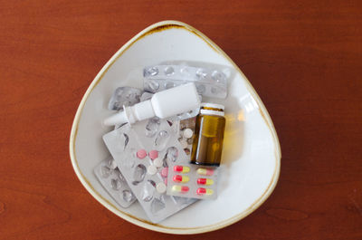 Many pills, drops. nose, packages and blisters with pills lie in a plate, table. healthcare, medical