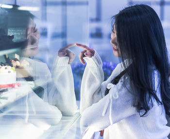 Woman looking at glass window in store