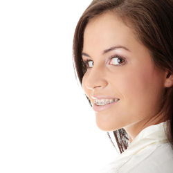 Close-up portrait of a smiling young woman over white background