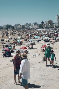 People on beach against clear sky