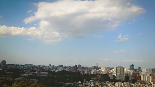 Aerial view of buildings in city against sky