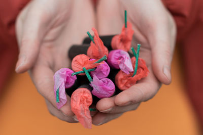 Close-up of hand holding pink flower