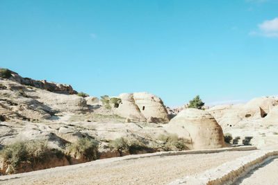 Scenic view of arid landscape against clear blue sky