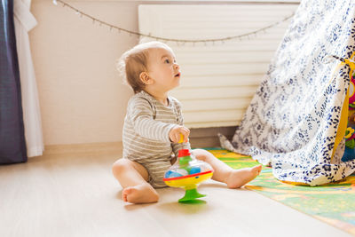 Cute boy playing with toy at home