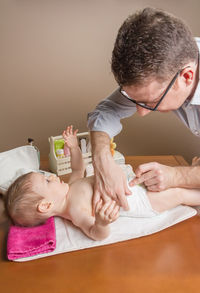 Father changing diaper of daughter