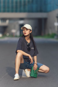 Portrait of young woman sitting on street