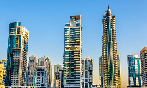 Low angle view of buildings against clear blue sky