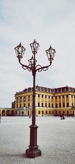 Street light by building against sky