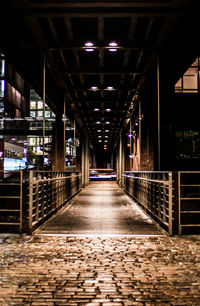 Illuminated corridor in city at night