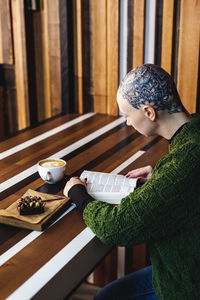 Side view of man holding tea cup on table