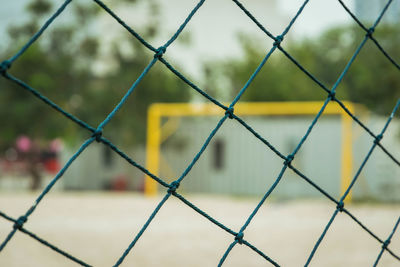 Rope net with blurred sand soccer field