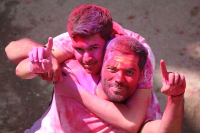 Portrait of smiling friends gesturing during holi