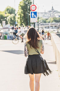 Rear view of woman walking on road