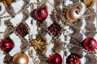 Christmas tree toys in the egg tray on a red background. the concept of new year's holidays.