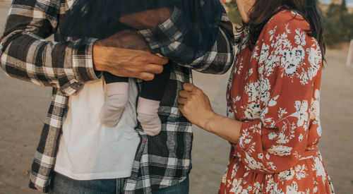 Midsection of couple standing outdoors