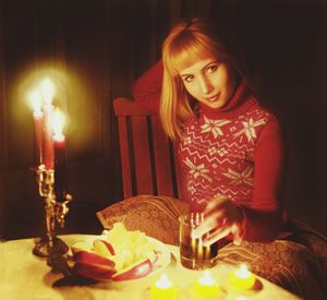 Portrait of young woman with cake on table at home
