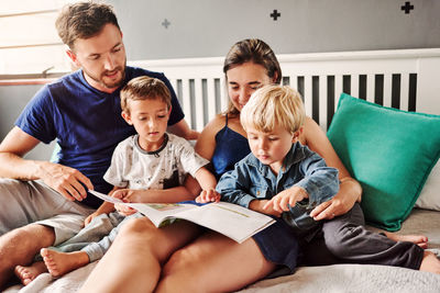Happy family reading story book at home