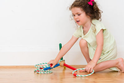 Full length of girl holding ring while playing at home