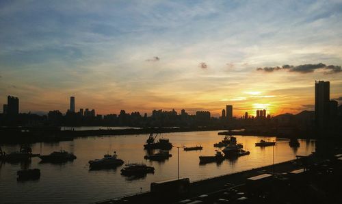 Boats in river at sunset