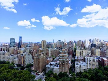 Aerial view of buildings in city against sky