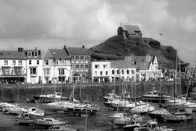 Boats moored at harbor against sky