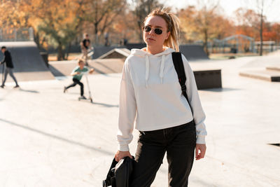 Portrait of young woman walking in city