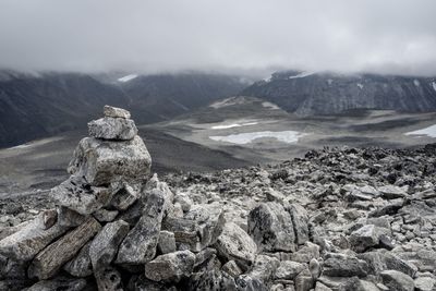 Stack of rocks on mountain against sky
