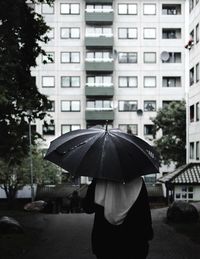 Rear view of woman walking in rain