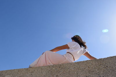 Low angle view of person against clear sky