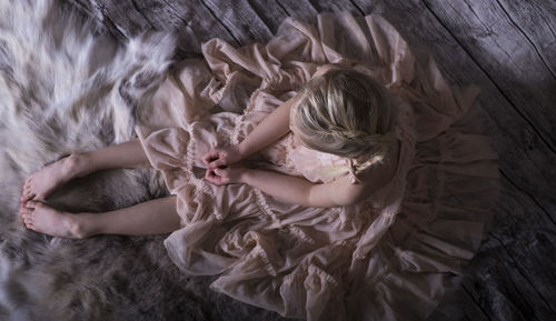 Directly above shot of girl sitting on hardwood floor