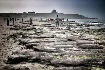 People on beach against sky