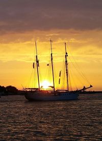 Sailboat in sea at sunset