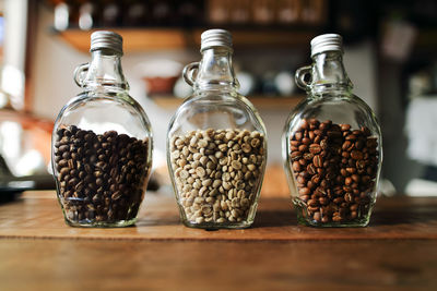 Close-up of coffee beans in jar on wooden table