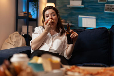 Portrait of young woman drinking glass