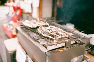 High angle view of eels cooking on barbecue at market stall