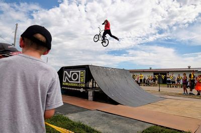 Man riding bicycle against sky