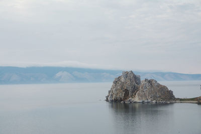 Rock formation in sea against sky