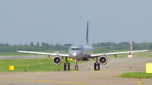 Airplane on runway against clear sky