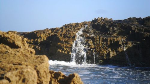 Scenic view of waterfall against clear sky