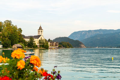 Scenic view of lake by building against cloudy sky