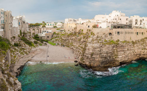 Lama monachile the famous beach of polignano a mare with a view of the city on the rock