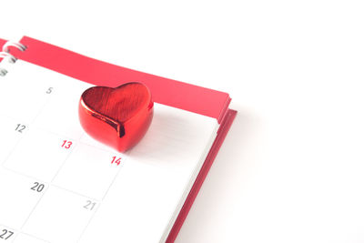 Close-up of heart shape on book against white background