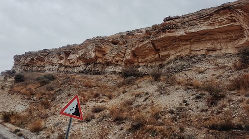 Low angle view of rock formation on mountain against sky