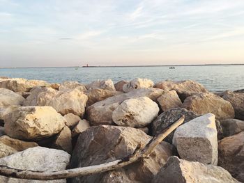 Rocks on sea shore against sky